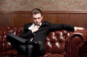 attractive young man in a suit sitting on couch