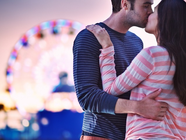 young couple kissing near santa monica pier